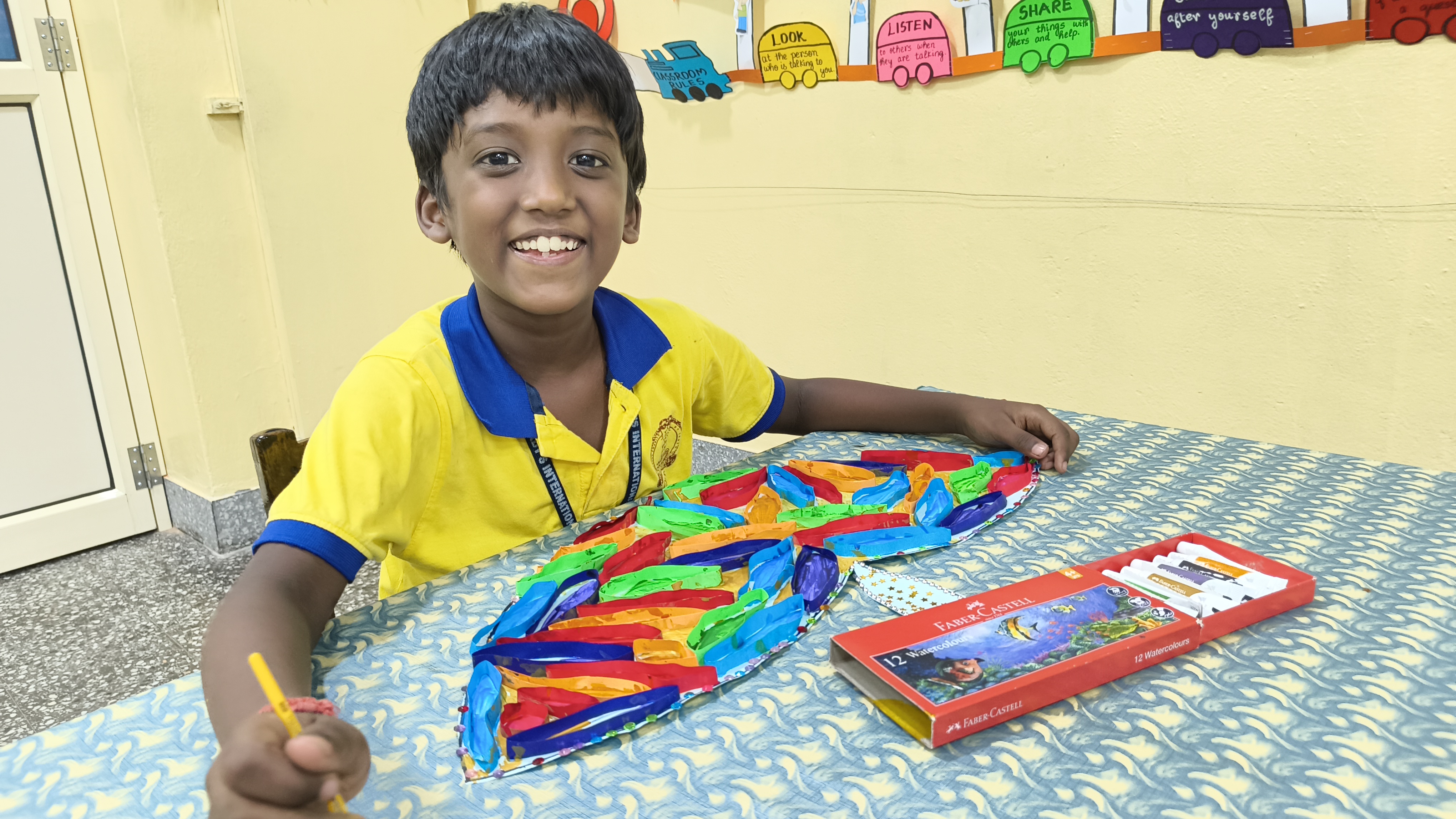 OLIS student smiling while working on a creative classroom activity